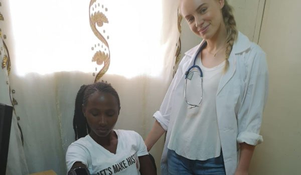 volunteer providing medical assitant to patient in uganda